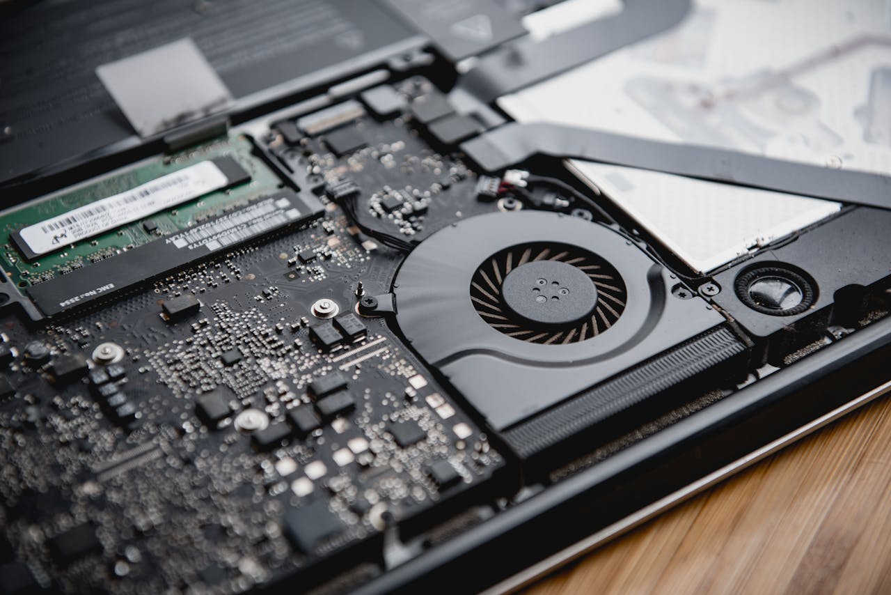 our-story Detailed view of a laptop's internal circuitry and cooling fan showcasing technology and engineering.